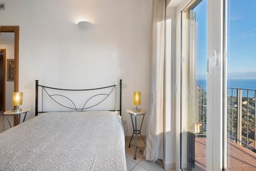 a white bedroom with a bed and a balcony at Casa Santi Appartamento Olivo in Giustenice