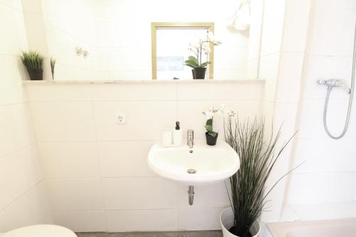 a white bathroom with a sink and a toilet at Downtown Apartments Ulm - im Herzen von Ulm & komfortable Boxspringbetten in Ulm