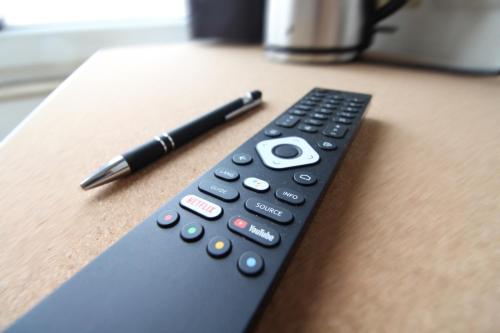 a remote control sitting on a table with a pen at Downtown Apartments Ulm - im Herzen von Ulm & komfortable Boxspringbetten in Ulm