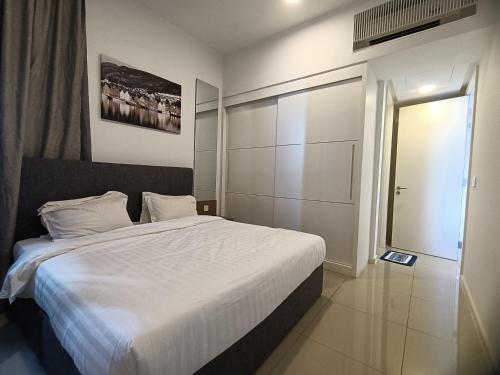 Un dormitorio con una gran cama blanca y una ventana en Pax 6+3 Grand Lux Melaka homestay en Melaka