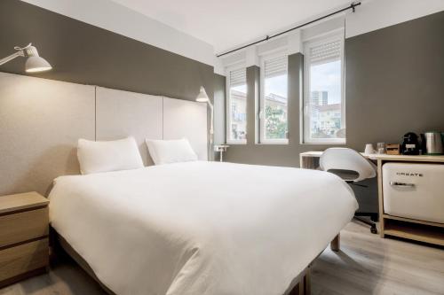 a bedroom with a large white bed and windows at Rainbow Suites by Olala Homes in Cascais