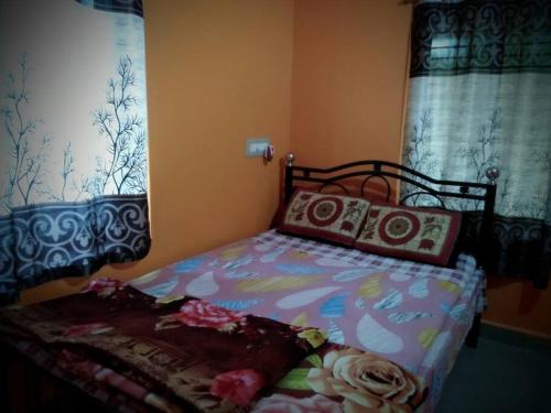 ein Schlafzimmer mit einem Bett mit einer bunten Bettdecke in der Unterkunft Kamanabillu Homestay, For jog falls travellers in Siddāpur