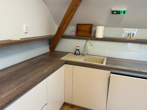 a kitchen with white cabinets and a sink at La Luna Rustic Deluxe Apartment with Free Jacuzzi, Bikes & Covered Parking in Našice