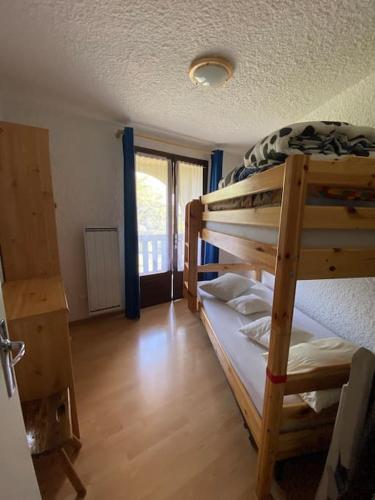 a bedroom with two bunk beds in a room at Laye Station - Appartement pieds des pistes in Laye