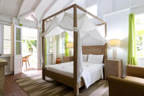 1 dormitorio con cama con dosel en una habitación en Fond Doux Eco Resort en Soufrière