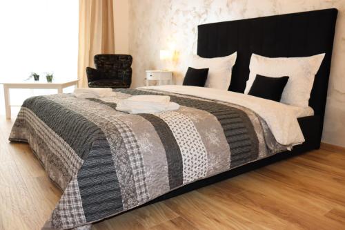 a bedroom with a large bed with a black headboard at All Homes by Nati in Braşov