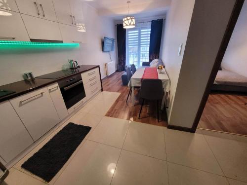 eine Küche und ein Esszimmer mit einem Tisch und einem Zimmer in der Unterkunft Apartament Grunwaldzka in Olecko