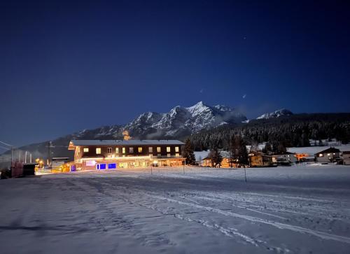 a house in the snow at night with a mountain at Fairhotel Hochfilzen B&B in Hochfilzen