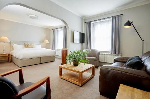 uma sala de estar com um sofá e uma cama em Abergavenny Hotel em Abergavenny