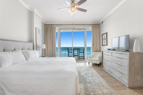 a bedroom with a bed and a television and a balcony at La Playa 301 in Perdido Key