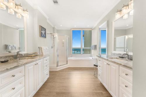 a white bathroom with two sinks and a shower at La Playa 301 in Perdido Key