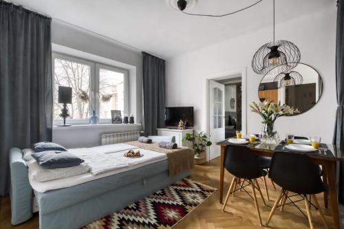 1 dormitorio con 1 cama, mesa y sillas en Parrot Dream.Stunning 2 bedrooms near metro&center, en Varsovia