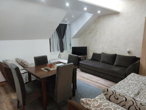 a living room with a couch and a table at Apartments Vila Djurdja in Kopaonik