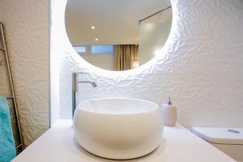 La salle de bains est pourvue d'un grand lavabo blanc sur un comptoir. dans l'établissement Stylish & modern 2 bedroom Apartment in Olympia Playa Las Americas, à Playa de las Americas