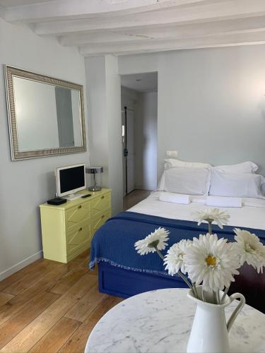 une chambre avec un lit et un vase de fleurs sur une table dans l'établissement CHARMING Paris 5 PANTHÉON LATIN QUARTIER, à Paris