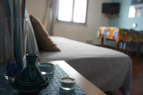 a table with a vase and two candles on a bed at BlueMind in Tropea