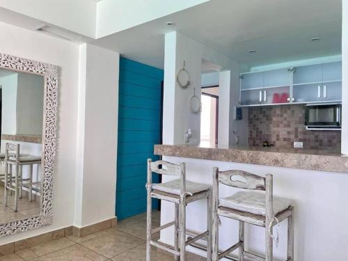 a kitchen with two stools at a bar with a mirror at Ocean Dreams by Andiani Travel in Cancún