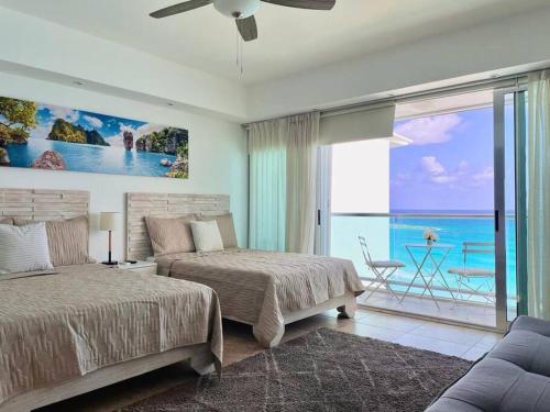 a bedroom with two beds and a view of the ocean at Ocean Dreams by Andiani Travel in Cancún