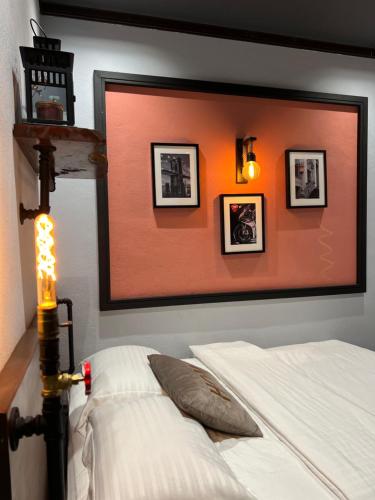 een slaapkamer met een bed en foto's aan de muur bij ZUSCH STUDIO in Pantai Cenang