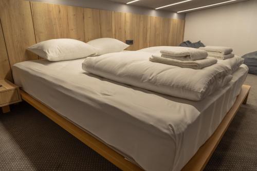 a large bed with white sheets and pillows on it at Luxury Apartments Anja in Jahorina