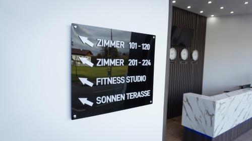 a sign hanging on a wall in a room at PARKHOTEL BRAUNAU - 24 Stunden Self Check-IN in Braunau am Inn