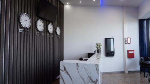a office with clocks on the wall and a counter at PARKHOTEL BRAUNAU - 24 Stunden Self Check-IN in Braunau am Inn