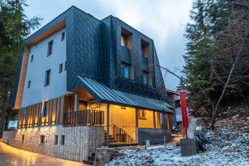 a house with a black roof at Luxury Apartments Anja in Jahorina
