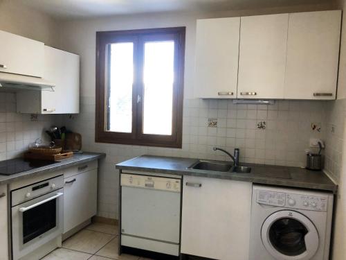 une cuisine avec un évier et une machine à laver dans l'établissement Appartement confortable à Saint-Martin, 60 m², jardin spacieux, à Saint-Martin-sous-Vigouroux