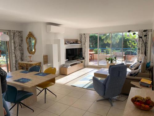 une cuisine et un salon avec une table et des chaises dans l'établissement Appartement du Palais -classé 4 étoiles - Axelle Loc'Appart, à Mandelieu-la-Napoule