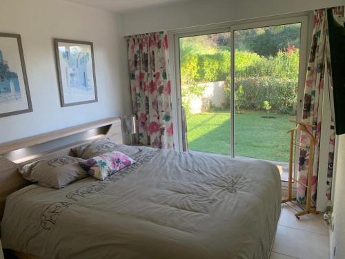 une chambre avec un lit et une grande fenêtre dans l'établissement Appartement du Palais -classé 4 étoiles - Axelle Loc'Appart, à Mandelieu-la-Napoule