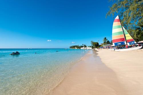 a beach with a sail boat in the water at Beacon Hill 304 by BSL Rentals in Saint Peter