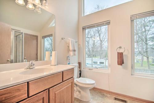 uma casa de banho com um lavatório, um WC e uma janela. em Twin Lakes Home - Walk to Lake Elizabeth! em Twin Lakes