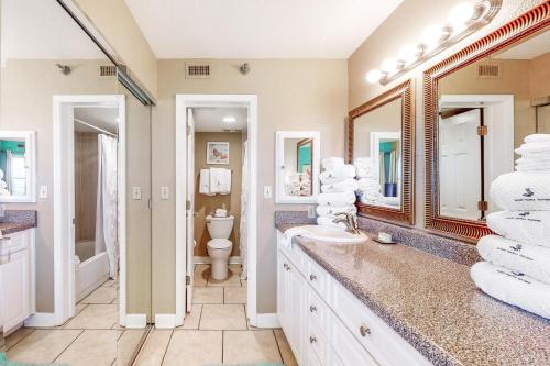 a bathroom with a sink and a toilet and a mirror at Perdido Sun 612 in Perdido Key
