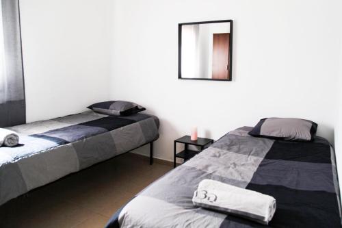 a bedroom with two beds and a mirror at Beautiful Apartment - Ben Yehuda - City Center in Jerusalem