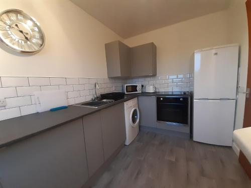 uma cozinha com um frigorífico branco e uma máquina de lavar louça em Carvetii - Iona House, 2nd floor apartment sleeps up to 6 em Kirkcaldy