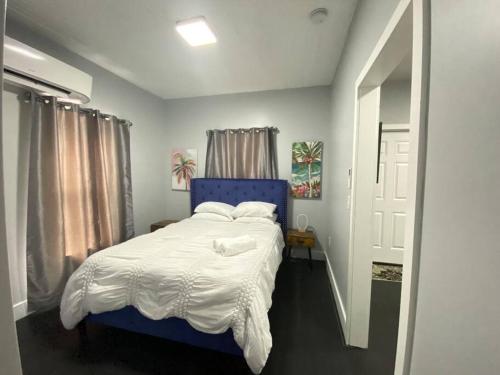 a bedroom with a blue bed with white sheets and pillows at The Mellow Yellow in Sanford
