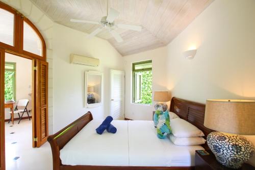 a bedroom with a bed and a ceiling fan at Marsh Mellow South Cottage by BSL Rentals in Saint James