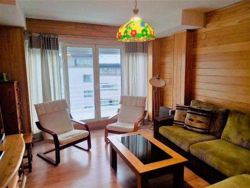 a living room with a couch and chairs and a chandelier at TODOSIERRANEVADA ZONA BAJA - MONTBLANC VISTAS A LA MONTANA - Junto a los Telecabinas in Sierra Nevada