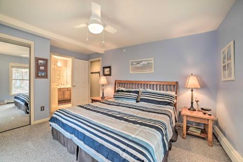 a bedroom with a large bed with blue walls at Portage Lake Condo with Deck and Pool Access! in Onekama