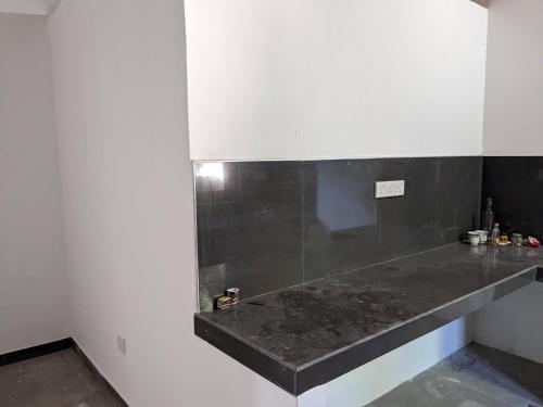 a kitchen with a black counter top in a room at Mango Tree Weligama in Weligama