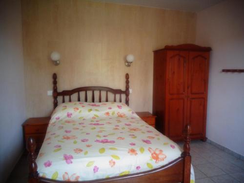1 dormitorio con 1 cama y armario de madera en Residence Madelia, en Port-Louis