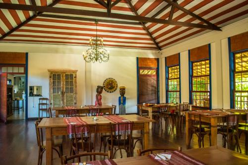 蒂拉登蒂斯的住宿－Pousada Candonga da Serra，一间带桌椅和吊灯的用餐室