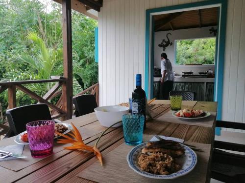 einen Tisch mit einem Teller Essen und einer Flasche Wein in der Unterkunft Mi Hermosa - Casa Isleña a 70 Metros de la Playa in Providencia