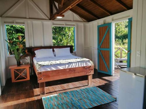 Dormitorio con cama y puerta colorida en Mi Hermosa - Casa Isleña a 70 Metros de la Playa, en Providencia
