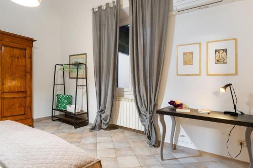 a bedroom with a bed and a desk and a window at Terme Apartment in Florence