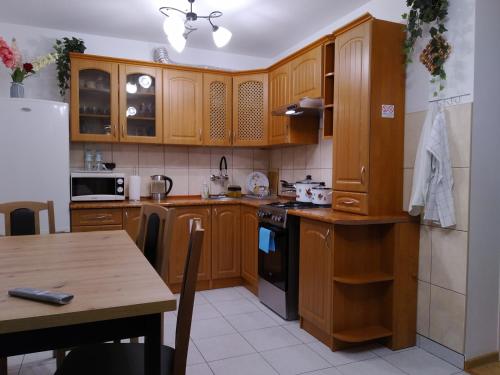 kuchnia z drewnianymi szafkami i drewnianym stołem w obiekcie Mieszkanie w Centrum Chełma w mieście Chełm
