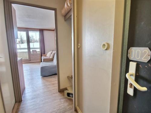 une porte ouverte sur un salon avec un canapé dans l'établissement *Nouveau* Pied des pistes * Piscine ext. chauffée*, à L'Alpe-d'Huez