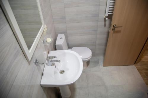a bathroom with a white sink and a toilet at Family Hotel Triston in Tbilisi City