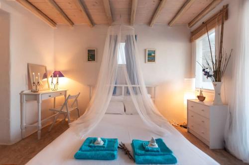 a bedroom with a bed with a mosquito net at Seafarer's House. Ideal for 3+1 guests in Mikonos