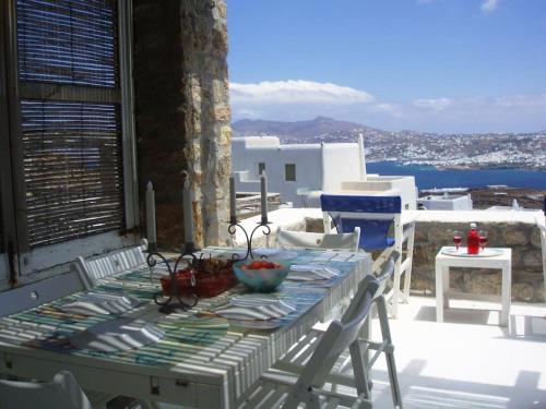 una mesa y sillas en un balcón con vistas al océano en Seafarer's House. Ideal for 3+1 guests, en Mykonos ciudad